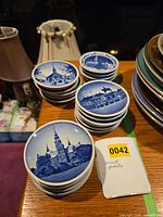 Stack and individual view of blue souvenir plates on a table