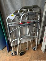 Three folded walkers leaning against wall