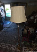 Full view of brass floor lamp with shade