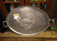Full view of oval hammered aluminum tray with handles and etched pinecone motif