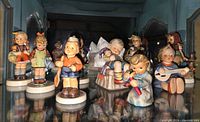 Group view of all ten Hummel figurines in display cabinet