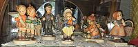 Front view of all five Hummel figurines in display case