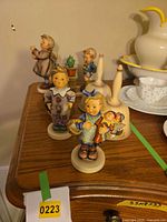 Group shot of three figurines and two bells on dresser