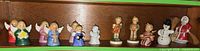 Shelf with seven angel ornaments, Hummel boy and girl, seated angel, snowman, Santa