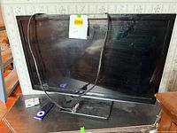 Front view of flat-screen TV with iPod, cable on stand