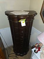 Full view of dark wood freestanding jewelry armoire chest