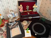 Overall lot showing jewelry box, figurines, decorative items and necklace tag
