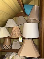 Multiple lamp shades stacked on shelves