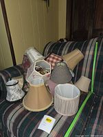 All lamp shades grouped on couch to show quantity and variety