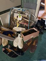 Group of various women’s shoes including sandals in clear bag, sneakers, slip-ons and boots