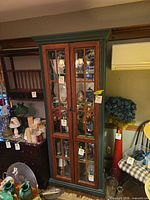 Full view of tall glass-door cabinet filled with display items