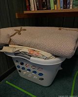 Laundry basket with folded comforter on top