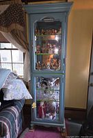 Front view showing full height, blue finish, glass doors and shelves