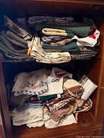 Full cabinet view upper and lower shelves filled with folded linens
