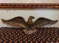 Front view of metal eagle with wings spread on stair tread