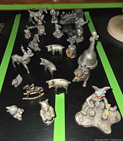 Overall view of pewter miniatures spread on black surface