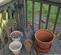 Group shot of metal planter chair and five assorted pots on deck