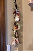 Full view showing multiple porcelain ornaments hanging on wall tree