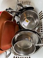 Assorted pans nested in basket—shows quantity, materials, handles