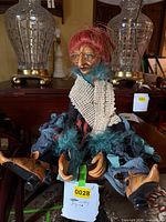 Full view of witch doll seated on furniture