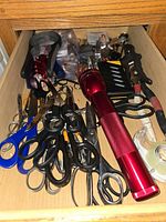 Drawer view with scissors, flashlight, tape, tools