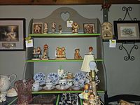Front view of gray wood wall shelf with heart cutout and three shelves