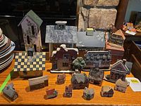 Full grouping of wooden and ceramic house figurines on shelf