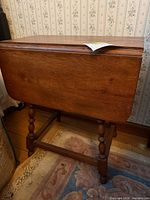 Table with one leaf down showing overall design and wallpaper backdrop