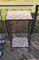 Full view of two-tier mosaic tile accent table outdoors