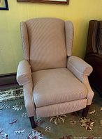 Front view of pinstripe upholstered wingback recliner armchair