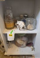 Overall view of top and bottom shelves showing assortment of jars and ceramic pieces