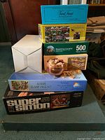 Stacked lot showing all boxed games and puzzles