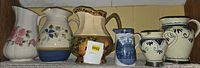Shelf view of all six ceramic pitchers