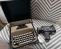 Underwood Leader typewriter open in case beside Nikon camera