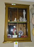 Front view of wooden wall cabinet showing glass door, shelf and overall condition