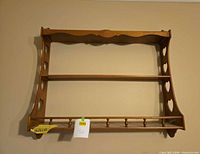 Front view of wooden wall shelf showing shelves, spindles, and heart cutouts