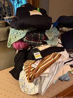 Stack of assorted women’s garments showing variety of colours, fabrics and some store tags