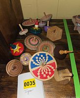 Group of assorted wooden tops on shelf