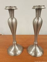 Front view of both brushed-silver candle holders