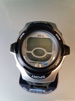 Front view of Brookes digital sport wristwatch on stand showing dial and button labels