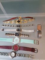 All nine watches laid out showing variety of bands and dials