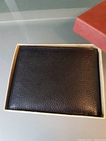 Wallet closed inside original box showing exterior leather texture