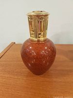 Full view of marbled glass Lampe Berger with gold-tone crown