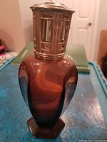 Full view of brown glass Lampe Berger lamp with metal crown