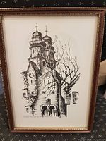 Framed ink drawing showing church tower with bare tree, gilt frame visible