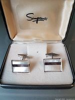 Open presentation box displaying both cufflinks and Simpsons logo