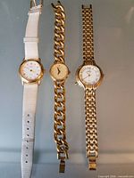 Three Timex watches: white leather strap, curb-link bracelet, woven bracelet