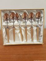 Six spoons arranged in satin-lined box