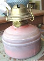 Side view of pink glass font and brass burner