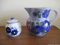 Pitcher and jam pot side by side on table